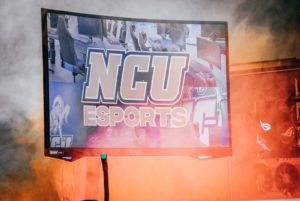 screen with "NCU Esports" on the front. Fog surrounds the screen.